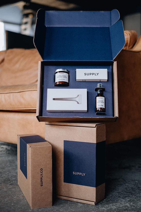 Small brown shipping box with custom blue insert packaging. The packaging separates different shaving products into an perfectly sized separate compartments.