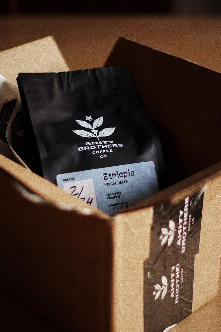 Black, branded coffee bag in small shipping box